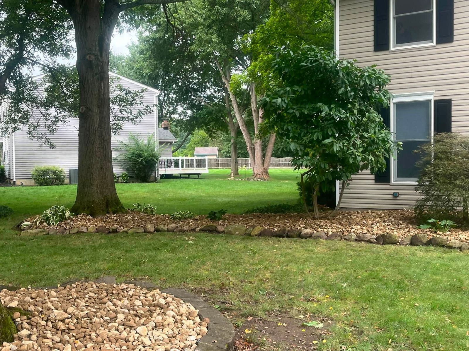 Stone border along the side of the house, beds cleared and lined